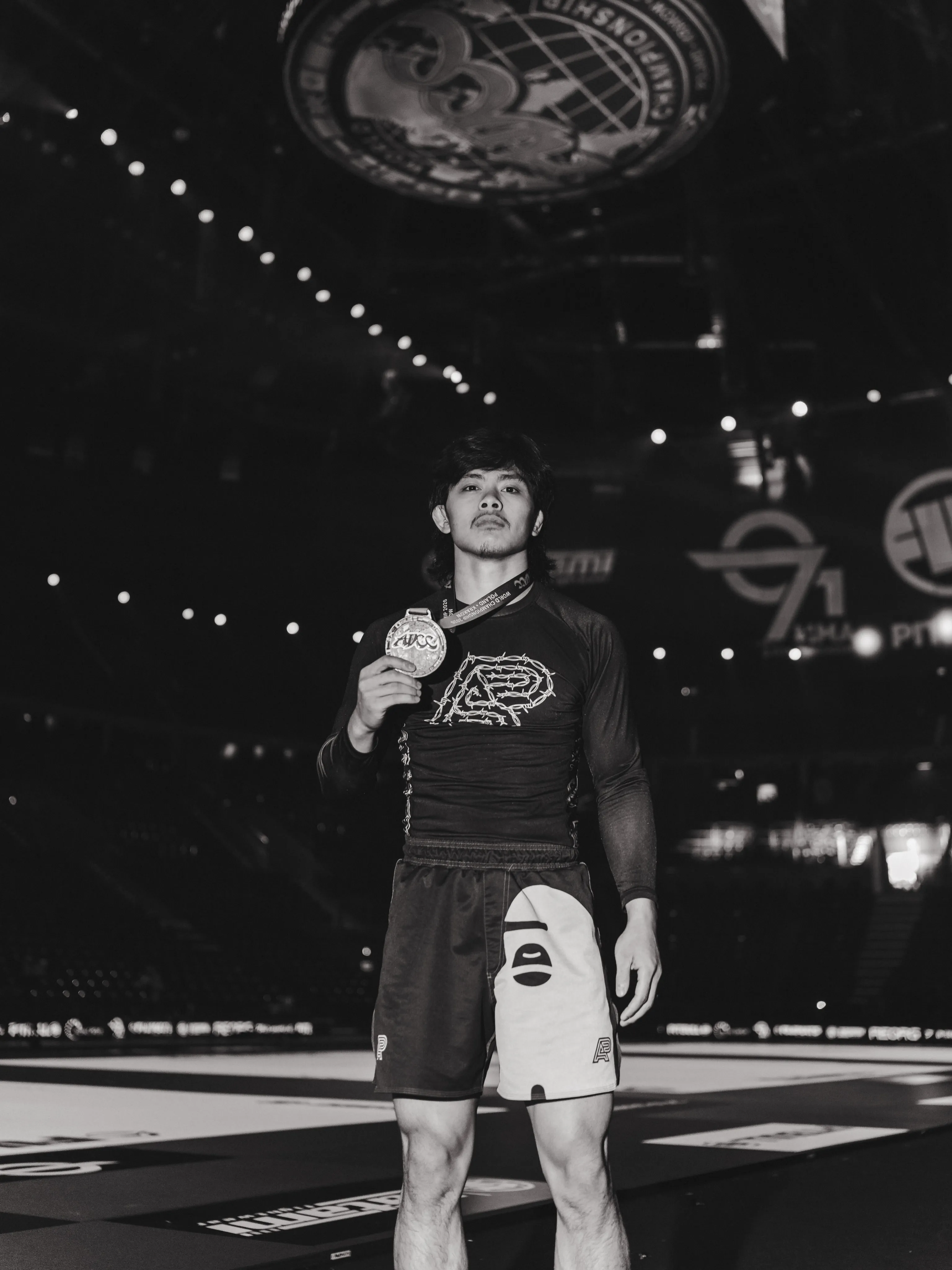 A grappler in the Albino and Preto kit poses with his medal Albino and Preto kit
